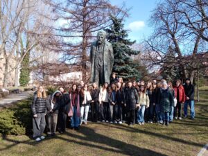 Zdjęcie przedstawia grupę osób na tle pomnika B. Prusa